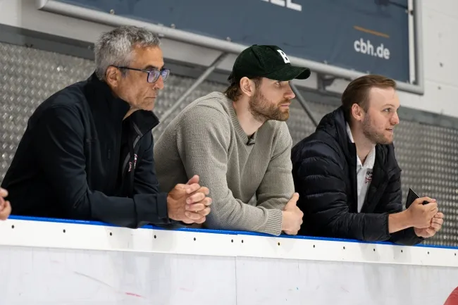 Rodion Pauels (l.) und U15-Trainer Julian Karadakic (r.) beobachten gemeinsam mit Leon Draisaitl das Training der U9.